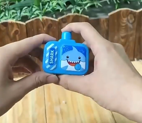 Mini Camera Water Gun in blue with shark design held in hands for kids party fun