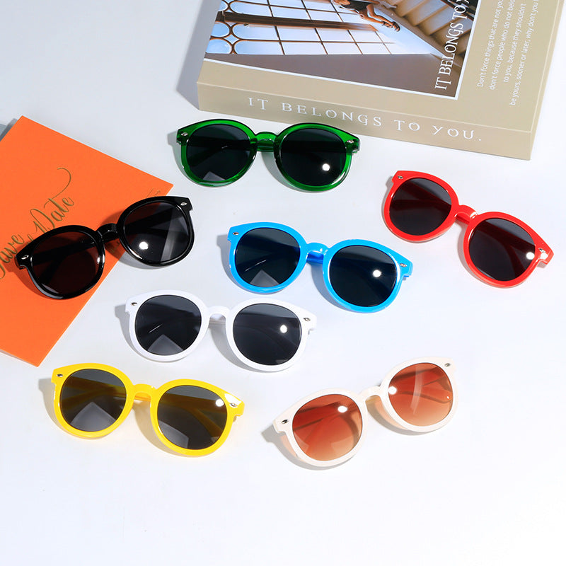 Colorful kids sunglasses in blue, red, yellow, green, white, black, and brown shades, perfect for party favors.