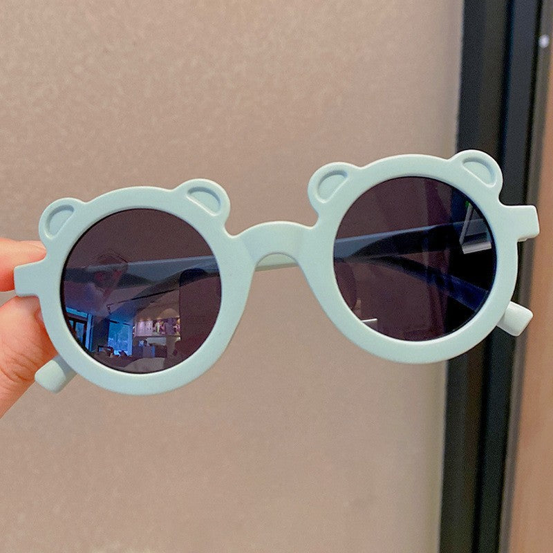 Kids Sunglasses with bear-shaped frames, Nordic style, held in hand.